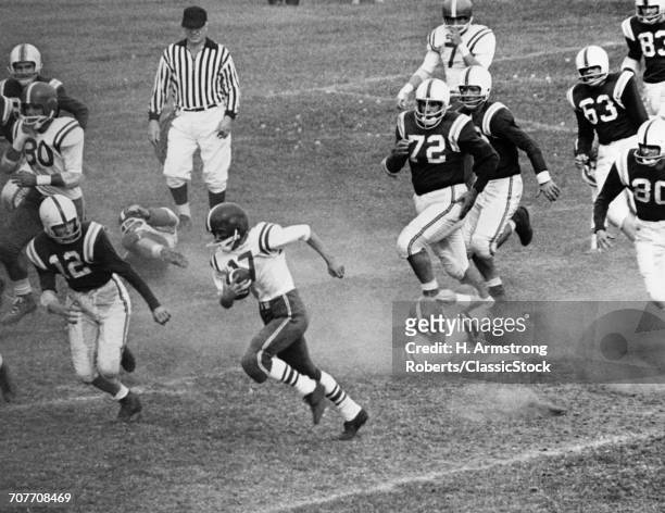 1970s COLLEGE OR HIGH SCHOOL FOOTBALL GAME WITH BALL CARRIER SURROUNDED BY MEMBERS OF OPPOSING TEAM IN PURSUIT