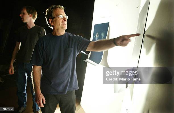 Photographer William Wegman views proofs from a promotional photo shoot of his Weimaraner dogs for the Tony Awards April 16, 2002 in New York City.