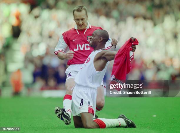 Ian Wright of Arsenal football club takes off his shirt and celebrates with team mate Lee Dixon after breaking Cliff Bastin's Arsenal goalscoring...