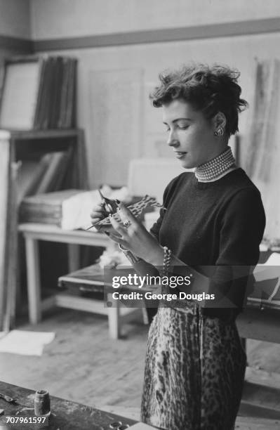 Elizabeth Stewart painting an accessory for a student charity fashion show for charity, held at the Glasgow School of Art, July 1952. Original...
