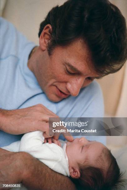French pop singer and actor Johnny Hallyday with his newborn daughter, Laura, from his relationship with French actress Nathalie Baye, Paris, 15th...