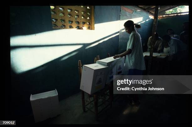 An unidentified woman places her vote in the box December 12, 1990 in Port Au Prince, Haiti. The elections was internationally supervised by former...