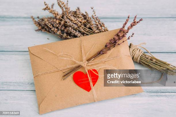 envelope with heart sticker and dried flowers - love letter stock-fotos und bilder