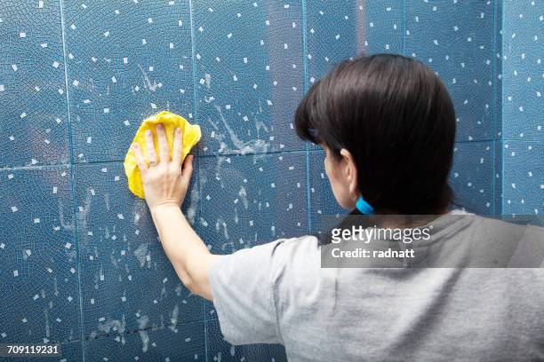 woman cleaning bathroom tiles - bathroom tiles stock pictures, royalty-free photos & images
