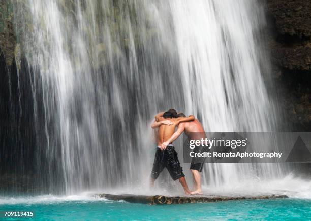 three men standing under waterfall, bohol island, philippines - bohol stockfoto's en -beelden