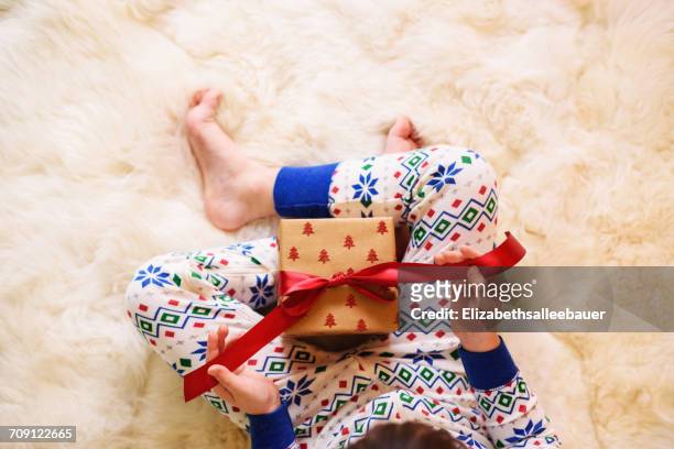 girl's sitting on floor opening a christmas gift - open day 2 stock pictures, royalty-free photos & images