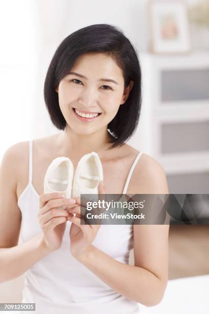 woman holding baby shoes - chinese baby shoe stock pictures, royalty-free photos & images