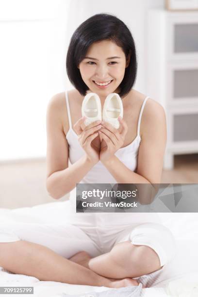 woman holding baby shoes - chinese baby shoe stock pictures, royalty-free photos & images