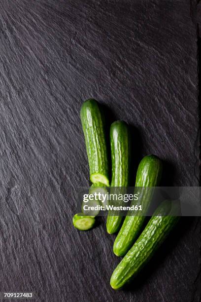 sliced and whole mini cucumber on slate - cucumber photos et images de collection