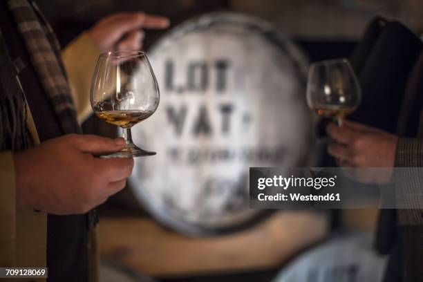 people in distillery tasing whiskey - whisky distillery stock-fotos und bilder