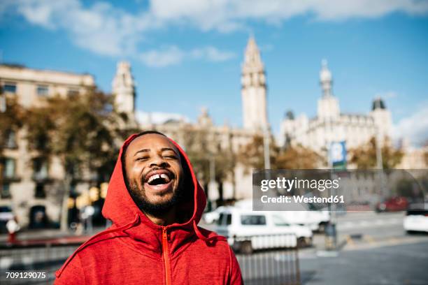 laughing young man in the city - vehicle hood stock-fotos und bilder