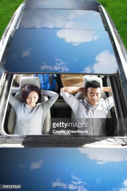 young couple driving on trip - couple sleeping in car stock-fotos und bilder