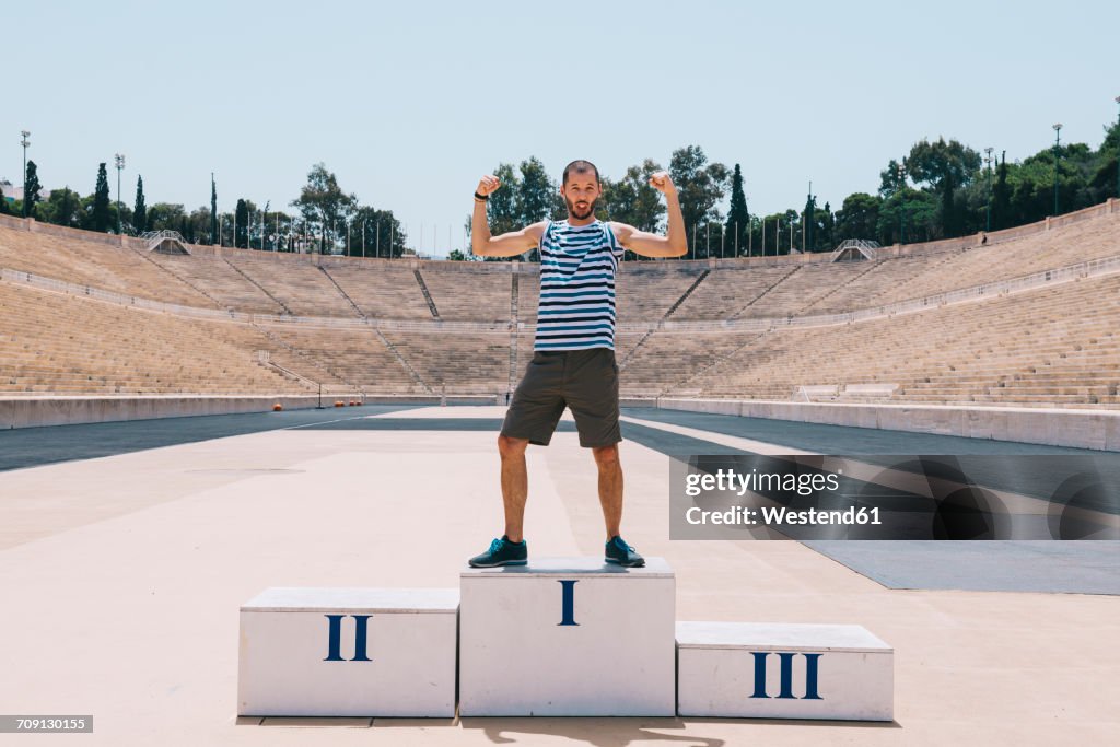 Greece, Athens, man on the podium celebrating in the Panathenaic Stadium