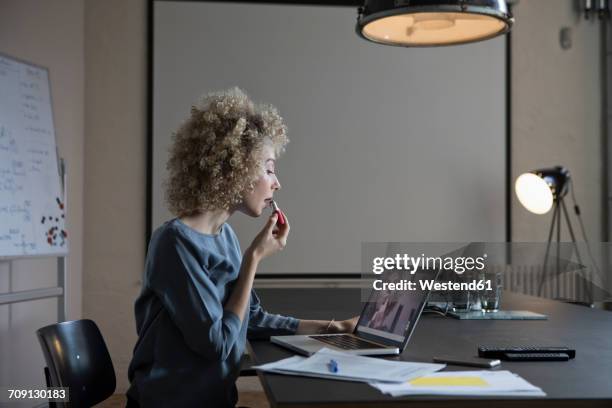 woman in office applying make-up using laptop monitor as mirror - person surrounded by computer screens stock pictures, royalty-free photos & images