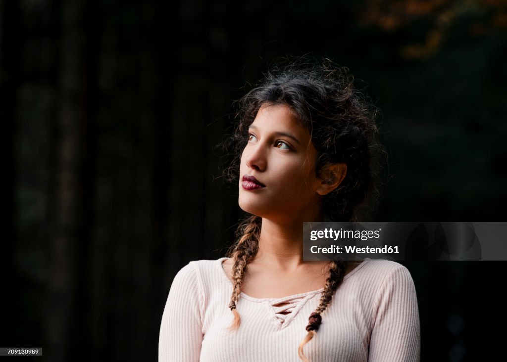 Portrait of young woman with braids in nature