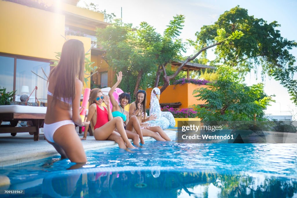 Four young women having fun at the poolside