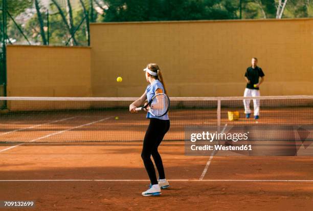 teenage girl training tennis with her teacher - tennis coaching photos et images de collection