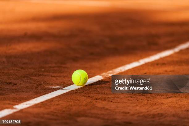 tennis ball hitting the line on clay court - tennis stock-fotos und bilder