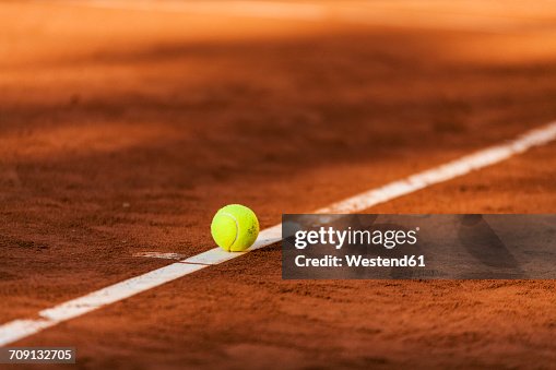 Tennis ball hitting the line on clay court Tennis ball hitting the line on clay court