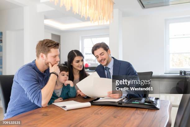 consultant talking to family at home - business couple showing stockfoto's en -beelden
