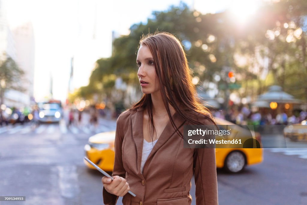 USA, New York, Manhattan, young businesswoman with tablet watching something