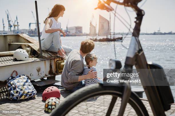 germany, hamburg, family having a break from a bicycle tour at river elbe - quayside stock pictures, royalty-free photos & images