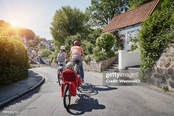 germany, hamburg, blankenese, family riding e-bikes - hamburg germany stockfoto's en -beelden