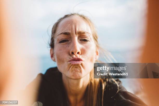 selfie of young woman pouting - gesicht verziehen stock-fotos und bilder