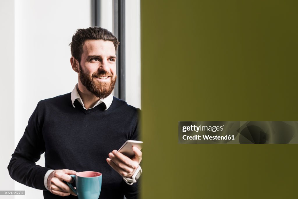 Businessman holding smart phone, talking