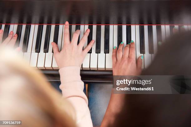 close-up of two girls playing piano together - pianist stock-fotos und bilder