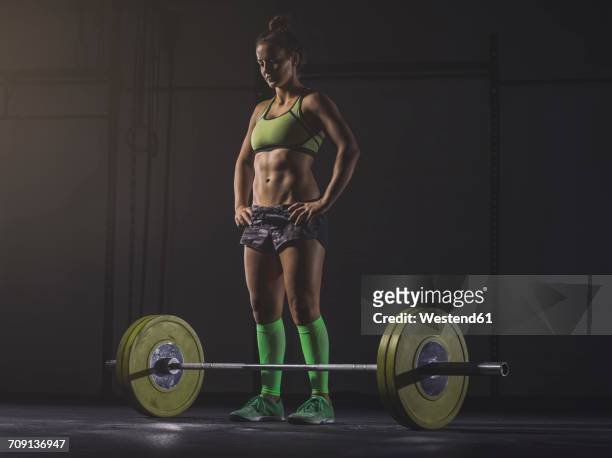 young woman preparing to lift barbell - ambient light stock pictures, royalty-free photos & images