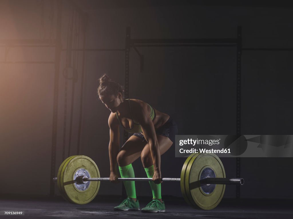 Young woman lifting barbell