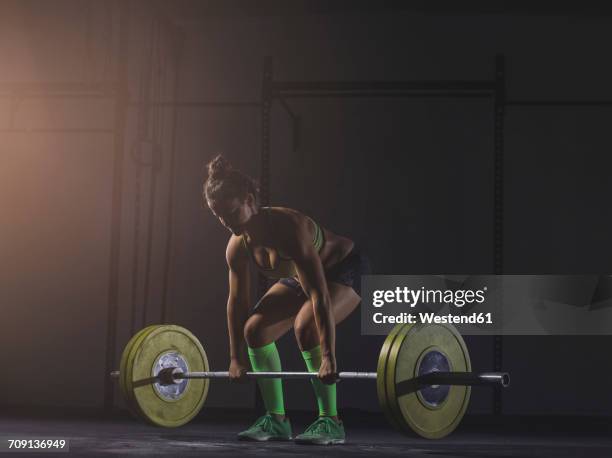 young woman lifting barbell - ambient light stock pictures, royalty-free photos & images