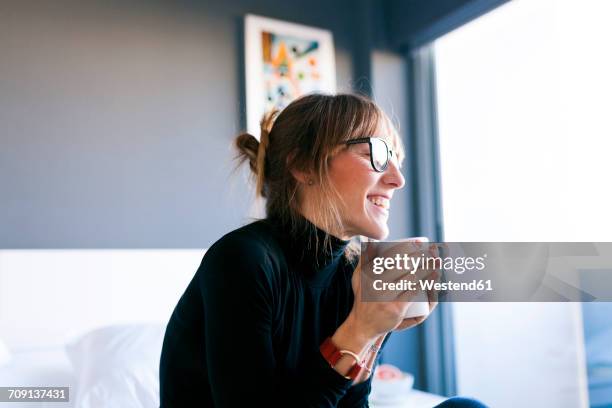 happy young woman at home drinking cup of coffee - adult woman cup tea stockfoto's en -beelden