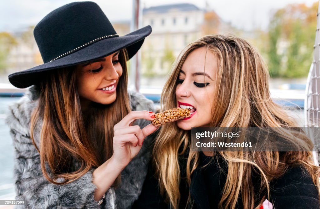 Paris, France, two tourists taking a cruise on Seine River eating a snack