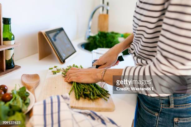 young woman cooking at home using digital tablet for recipe - recipe bildbanksfoton och bilder
