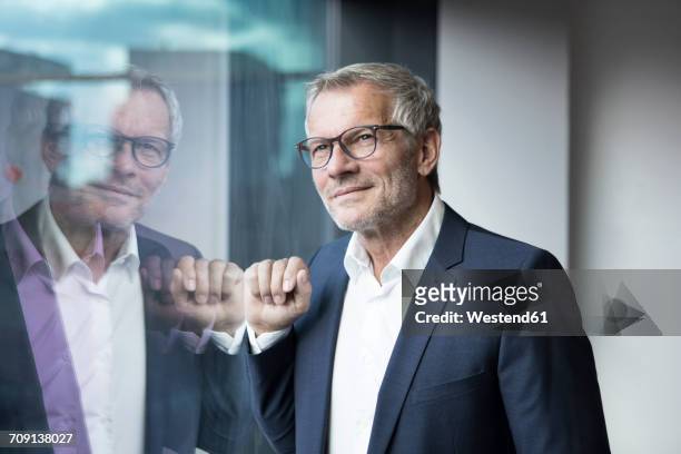 confident businessman looking out of window - the project portraits stock-fotos und bilder