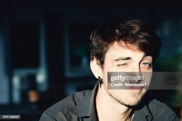 portrait of a young man twinkling - head torch stock-fotos und bilder