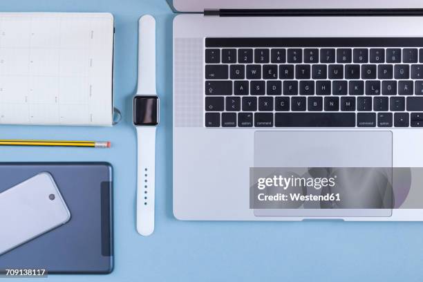 various electronic devices, personal organizer and a pencil on blue ground - multiple smart devices stock-fotos und bilder