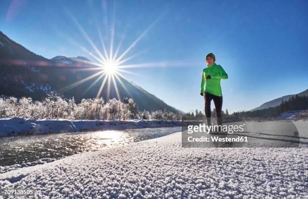 germany, bavaria, isar valley, vorderriss, woman jogging in winter - alleen één oudere vrouw stockfoto's en -beelden