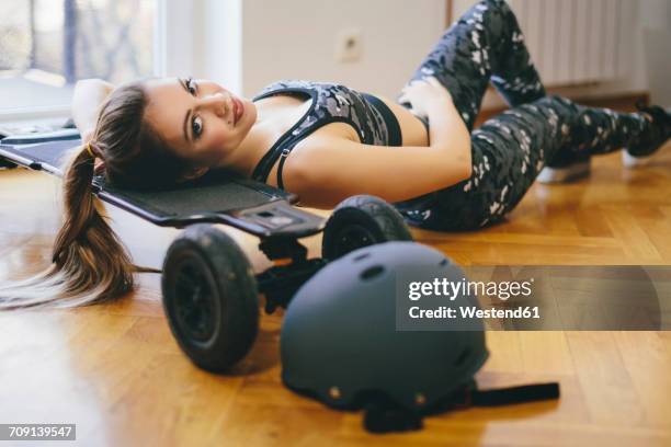 young woman lying on skateboard - electric skateboard stock pictures, royalty-free photos & images