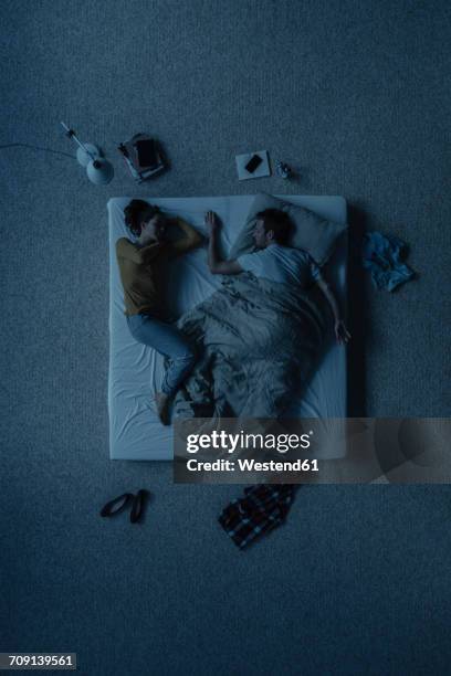 couple lying in bed, top view - above view of man sleeping on bed stock-fotos und bilder
