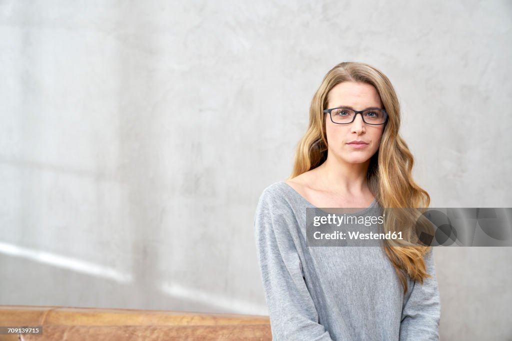 Portrait of serious blond woman wearing glases