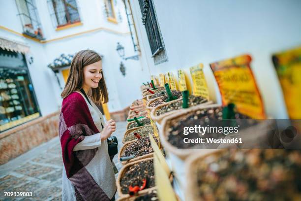 young woman in sevilla looking at spice shop - seville fotografías e imágenes de stock