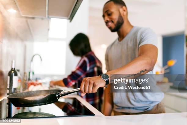 young couple cooking together at home - male forearm tattoos stock pictures, royalty-free photos & images