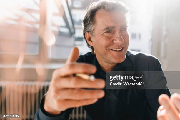 portrait of smiling mature businessman - gesturing foto e immagini stock