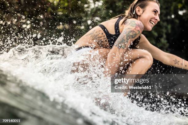 indonesia, java, happy woman surfing - woman surfing stock pictures, royalty-free photos & images