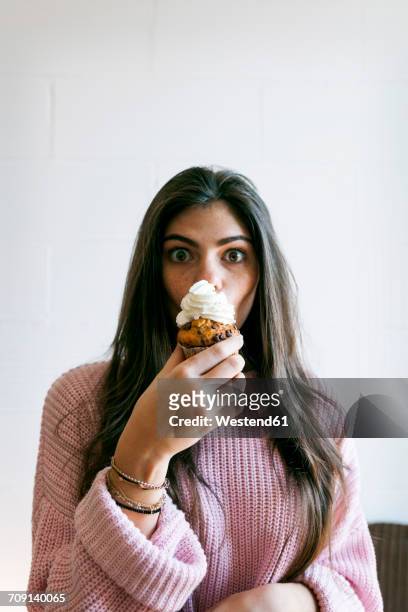 young woman eating a cup cake with whipped cream - whip cream cake - fotografias e filmes do acervo