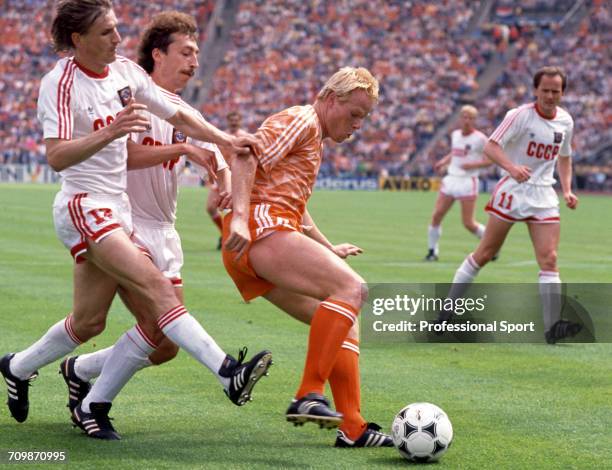 Dutch footballer Ronald Koeman of the Netherlands team is tackled for the ball by Soviet player Sergei Aleinkov during play against the Soviet Union...