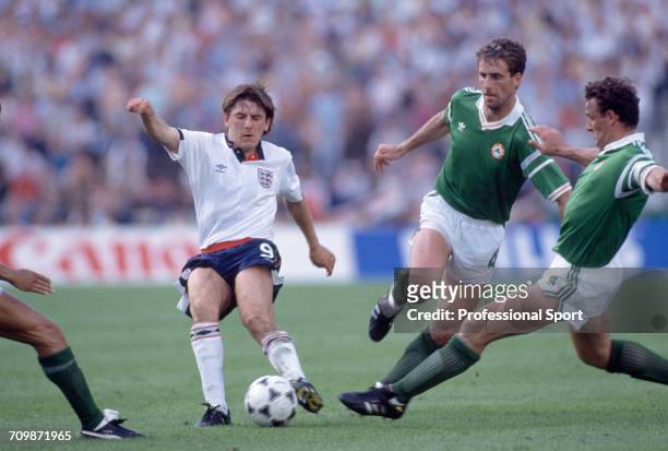 English footballer Peter Beardsley is tackled for the ball by Republic of Ireland players Kevin Moran and Mick McCarthy during play in the group 2...